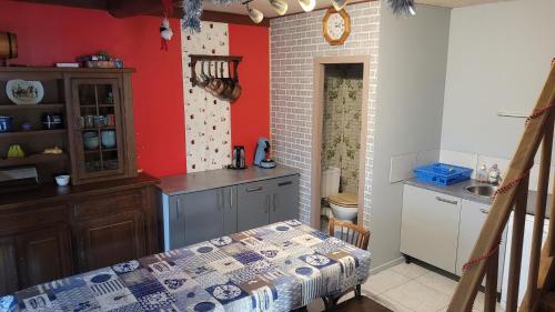 een keuken met rode muren en een tafel in een kamer bij Maison De Vacances A Freconrupt in La Broque