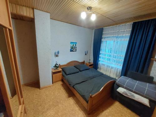 a small bedroom with a bed and a couch at Садиба Маковиця in Yaremche