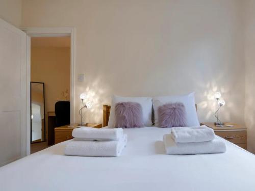 a large white bed with two pillows on it at Pass the Keys Modern and Spacious Terrace in Central Cambridge in Cambridge