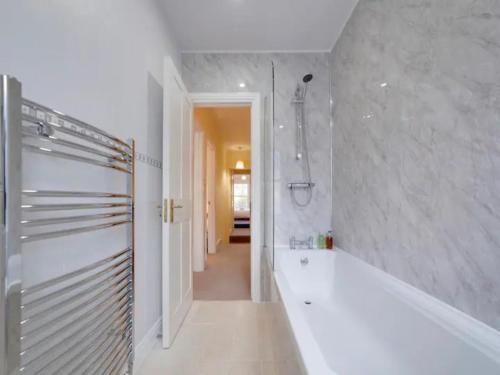 a bathroom with a tub and a walk in shower at Pass the Keys Modern and Spacious Terrace in Central Cambridge in Cambridge
