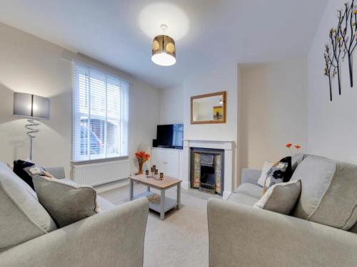 a living room with two couches and a fireplace at Pass the Keys Modern and Spacious Terrace in Central Cambridge in Cambridge