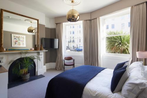 a bedroom with a bed and a fireplace and a mirror at Lansdowne House Hove in Brighton & Hove