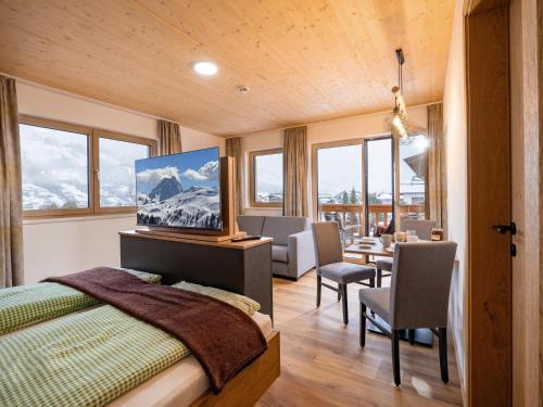 a bedroom with a bed and a table and chairs at M&M Appartements Brixental in Westendorf