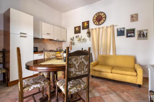 a kitchen with a table and a yellow chair at Casa Michela in Viddalba