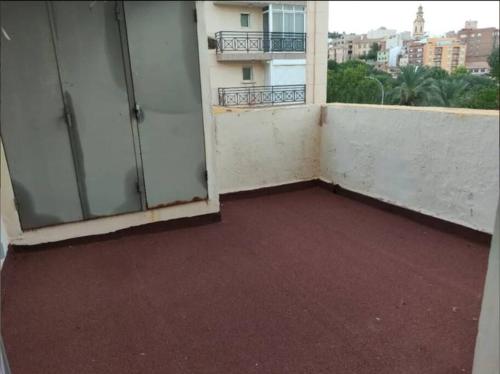 un balcón vacío de un edificio con suelo rojo en Real Fábrica del Conde de Aranda, en Alcora