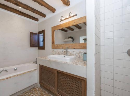 a bathroom with a sink and a tub and a mirror at Villa Can Truy in Sant Josep