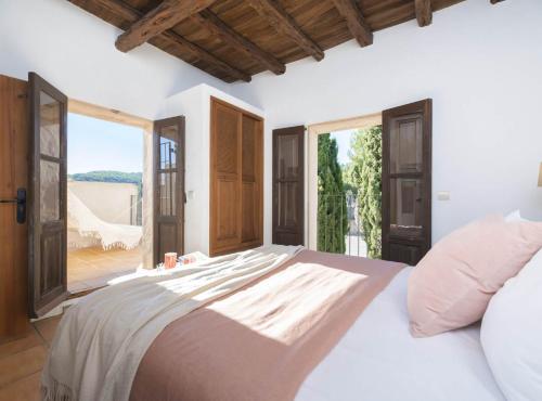 a bedroom with a large bed and a large window at Villa Can Truy in Sant Josep