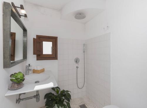 a white bathroom with a sink and a shower at Villa Can Truy in Sant Josep