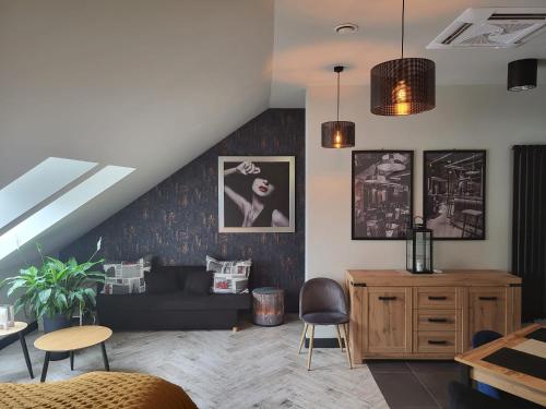 a living room with a couch and some chairs at Apartamenty Terminal Charzykowy in Charzykowy