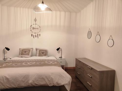a bedroom with a bed and two lamps and a dresser at Maison de village à maligny 89 in Maligny