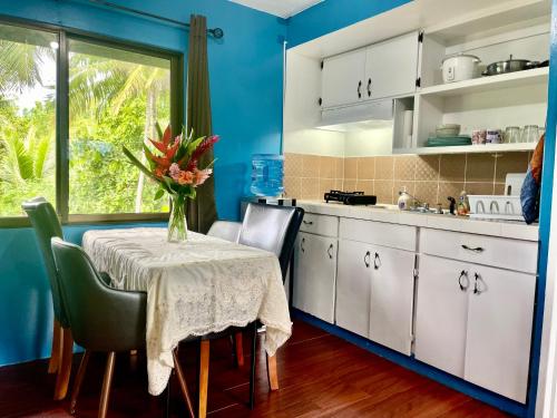 a kitchen with a table with a vase of flowers on it at Ngermid Oasis Cozy 2 BD 1BA Home, Scenic View, Secluded, Beautiful Location in Koror