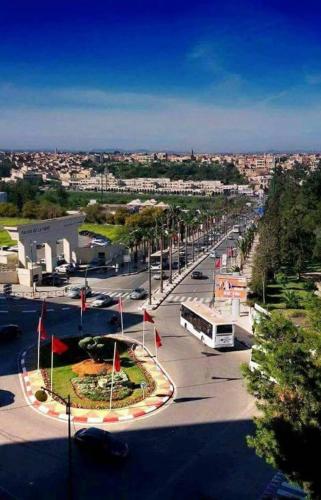 a city street with a bus parked in a parking lot at Apartment Meknes Hamria in Meknès