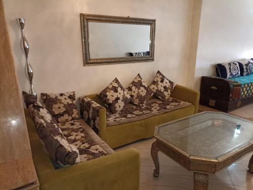 ein Wohnzimmer mit 2 Sofas und einem Spiegel in der Unterkunft Nouvel Appartement Hamria in Meknès