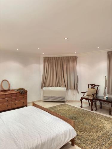um quarto com uma cama, uma mesa e uma janela em مساكن الدار 15 em Abha