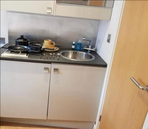 a kitchen counter with a sink and a stove at Affordable Flats - Derby City Centre in Derby