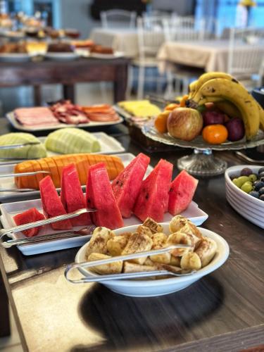 a table topped with plates of fruits and vegetables at Olinda Hotel e Eventos in Toledo