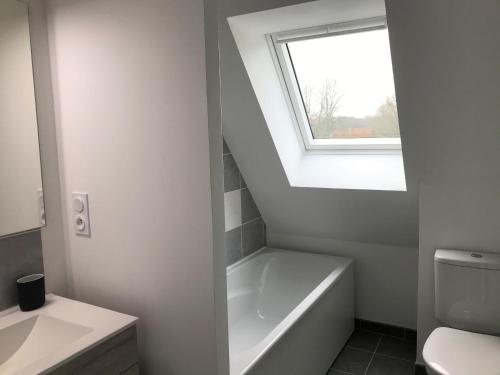 une salle de bain avec une baignoire et une fenêtre dans l'établissement Cedre, à Varengeville-sur-Mer