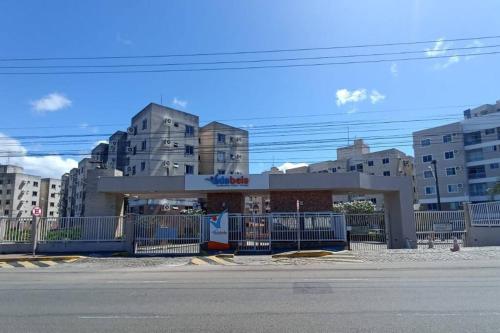 Ein Gebäude mit einem blauen Zaun in einer Stadt in der Unterkunft Apartamento Clube 3/4 com Ar-condicionado in Aracaju