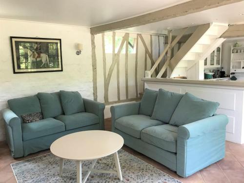 un salon avec deux canapés bleus et une table dans l'établissement Petit Clos, à Varengeville-sur-Mer
