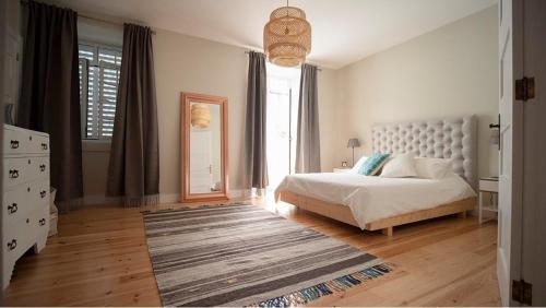a bedroom with a bed and a large window at Casa Memorial Miguel Faial - Relaxing Patio in Ponta Delgada