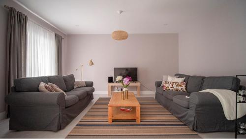 uma sala de estar com dois sofás e uma mesa de centro em WelcomeBuddy - Casa Memorial Miguel Faial em Ponta Delgada