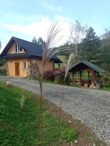 a house with a gravel road in front of it at Domek nad Stawem Siemuszowa in Tyrawa Wołoska