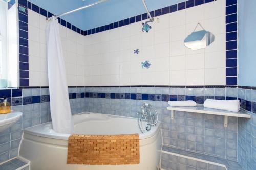 een blauwe en witte badkamer met een bad en een wastafel bij The Westlands Apartment High Barnes Sunderland in Pallion