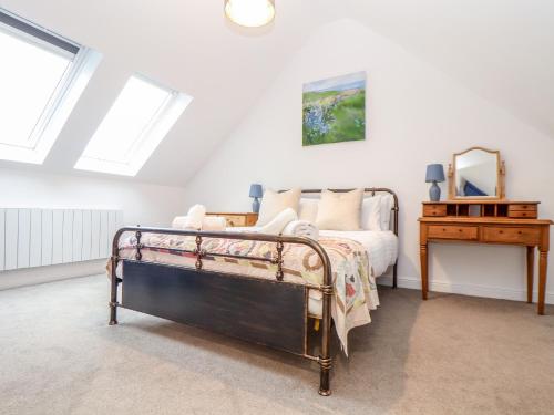 a bedroom with a bed and a desk with a mirror at Wildwood in Newquay