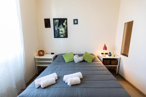 a bedroom with a blue bed with two pillows at Rogoredo - Exclusive Apartment in Milan