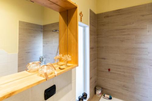 a bathroom with a wooden shelf and a shower at Rogoredo - Exclusive Apartment in Milan