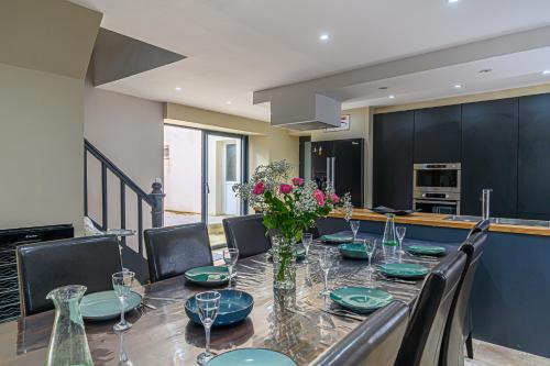 une salle à manger avec une table et des chaises et une cuisine dans l'établissement Le clos Arthur, à Pluneret