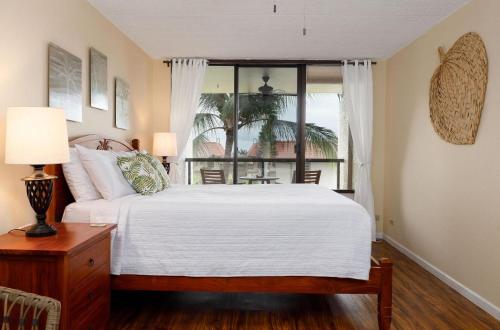 Un dormitorio con una cama grande y una ventana. en Kona Pacific C618 Top fl Seaview With ac, Elevator, en Kailua-Kona