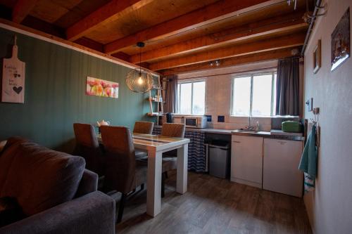 een keuken met een tafel en stoelen in een kamer bij Sfeervol Appartement Het Knooppunt in Nuis