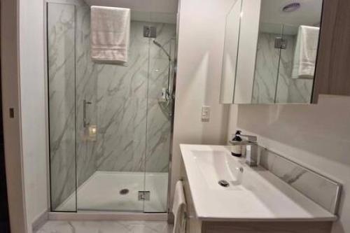 a white bathroom with a shower and a sink at Lovely Brand New Home 26 in Christchurch