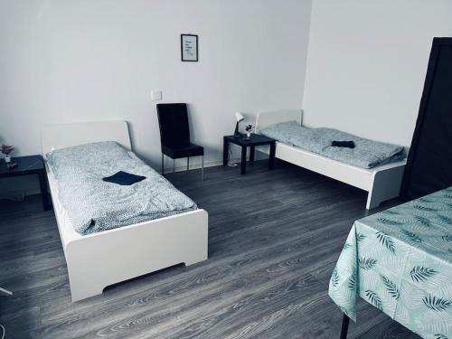 a room with two beds and a table and chairs at StadtHOUSE Bentheim Viel Platz für Gruppen in Bad Bentheim