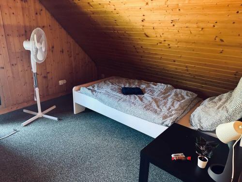 Cette chambre mansardée comprend un lit et un ventilateur. dans l'établissement Personalunterkunft in Bad Bentheim bis 14 Personen, à Bad Bentheim