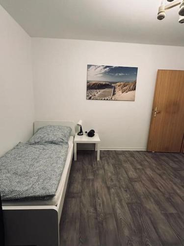 ein Schlafzimmer mit einem Bett und einem Tisch darin in der Unterkunft Personalunterkunft in Rheine mit Balkon in Rheine