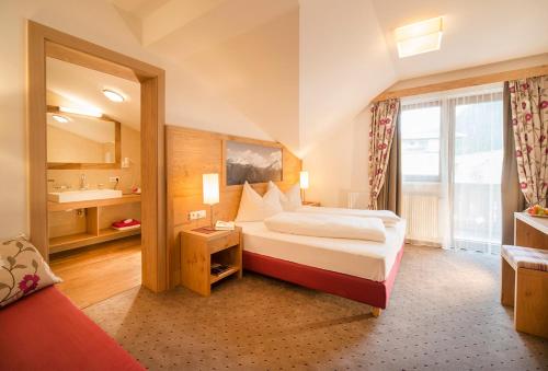 um quarto de hotel com uma cama e uma janela em Landhaus Lexner em Tux