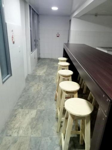 a row of stools at a bar in a room at Hospedaje Cristiano Almagor in Bogotá