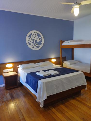 um quarto azul com uma cama com 2 beliches em Joaquina Beach Hotel em Florianópolis