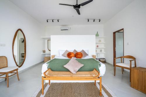 a bedroom with a bed with two oranges on it at Ozkar Villa Canggu in Canggu