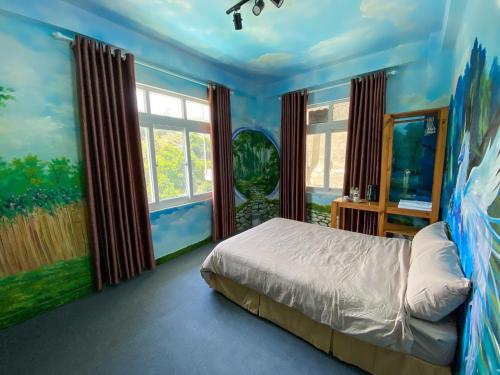 ein Schlafzimmer mit einem Bett und einem Wandgemälde in der Unterkunft The New House in Ấp Ða Lợi