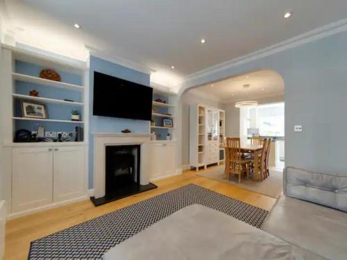 a living room with a fireplace and a flat screen tv at Pass the Keys Centrally located modern and spacious 3 Bed terrace in Cambridge