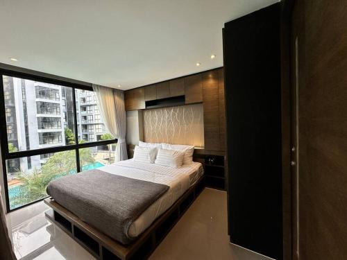 a bedroom with a bed and a large window at Kamala poolview 2 bedroom suite in Kamala Beach