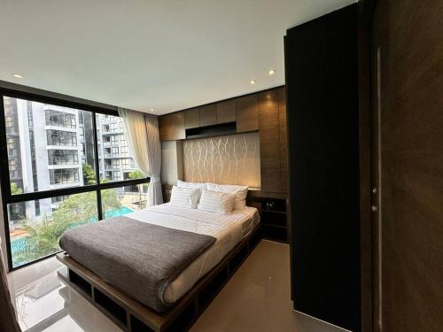 une chambre avec un lit et une grande fenêtre dans l'établissement Kamala Beach P33 Pool view 2 Bedroom Suite, à Kamala Beach