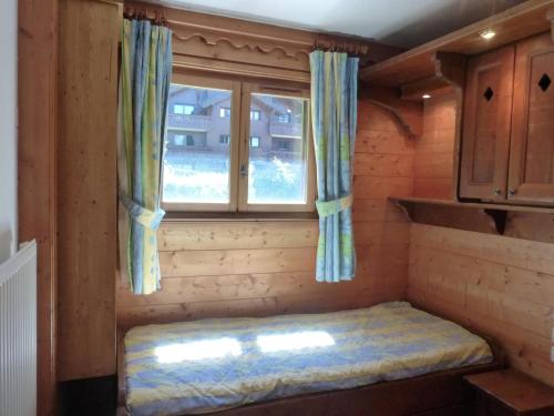 un petit lit dans une chambre avec une fenêtre dans l'établissement Appartement 3 pièces 6 pers à Méribel Village, pied des pistes, balcon, piscine chauffée - FR-1-411-602, à Les Allues