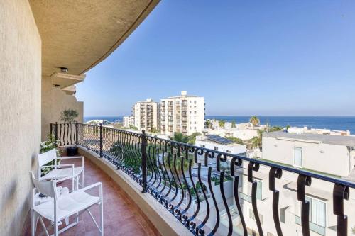 a balcony with chairs and a view of the ocean at Lovely apartment next to the beach in St. Paul's Bay