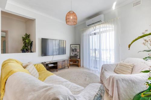 a living room with a couch and a flat screen tv at Lovely apartment next to the beach in St. Paul's Bay