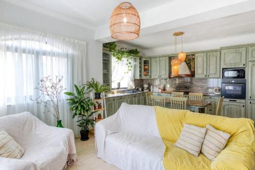 a living room with a white couch and a kitchen at Lovely apartment next to the beach in St. Paul's Bay