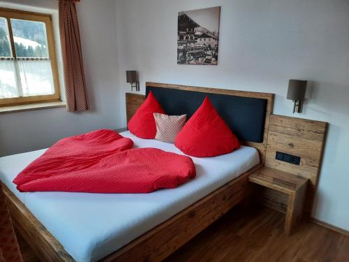 a bedroom with a bed with red pillows on it at Beim Draxl in Reit im Winkl